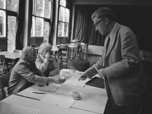 A hand passes a voting pass to another hand.