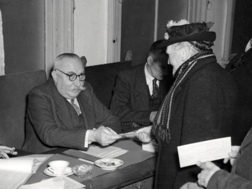 A sitting man is facing a standing woman.