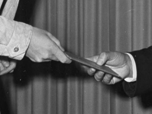 A man gives his ID card to another man.